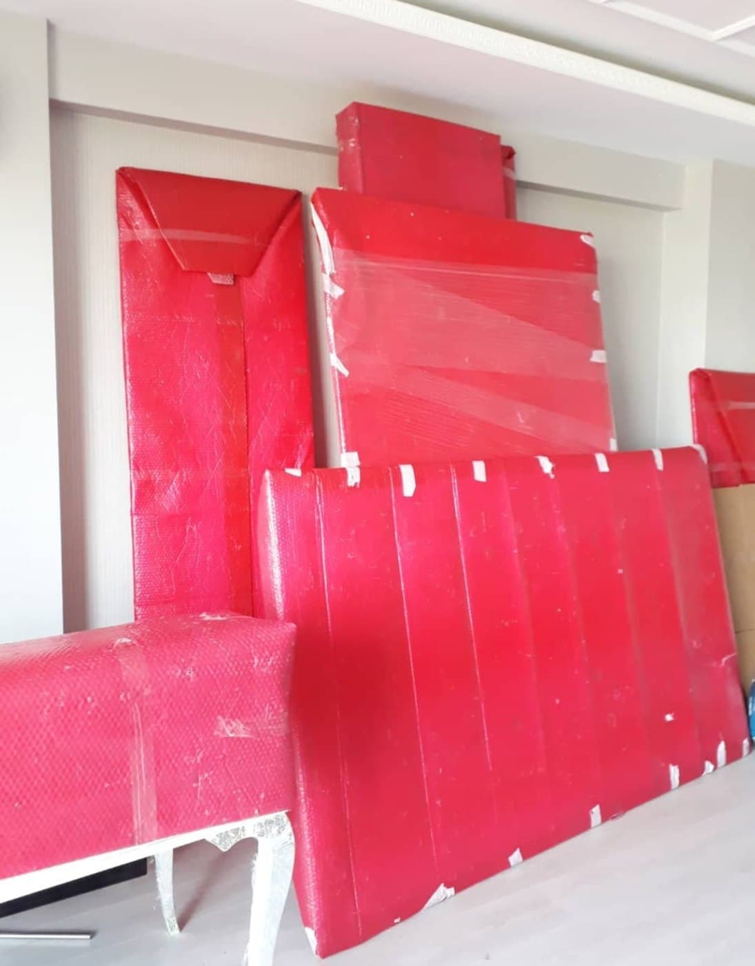 Ambalaj örtüsüyle sarılıp bantlanmış gardırop kapakları ve karyola parçaları