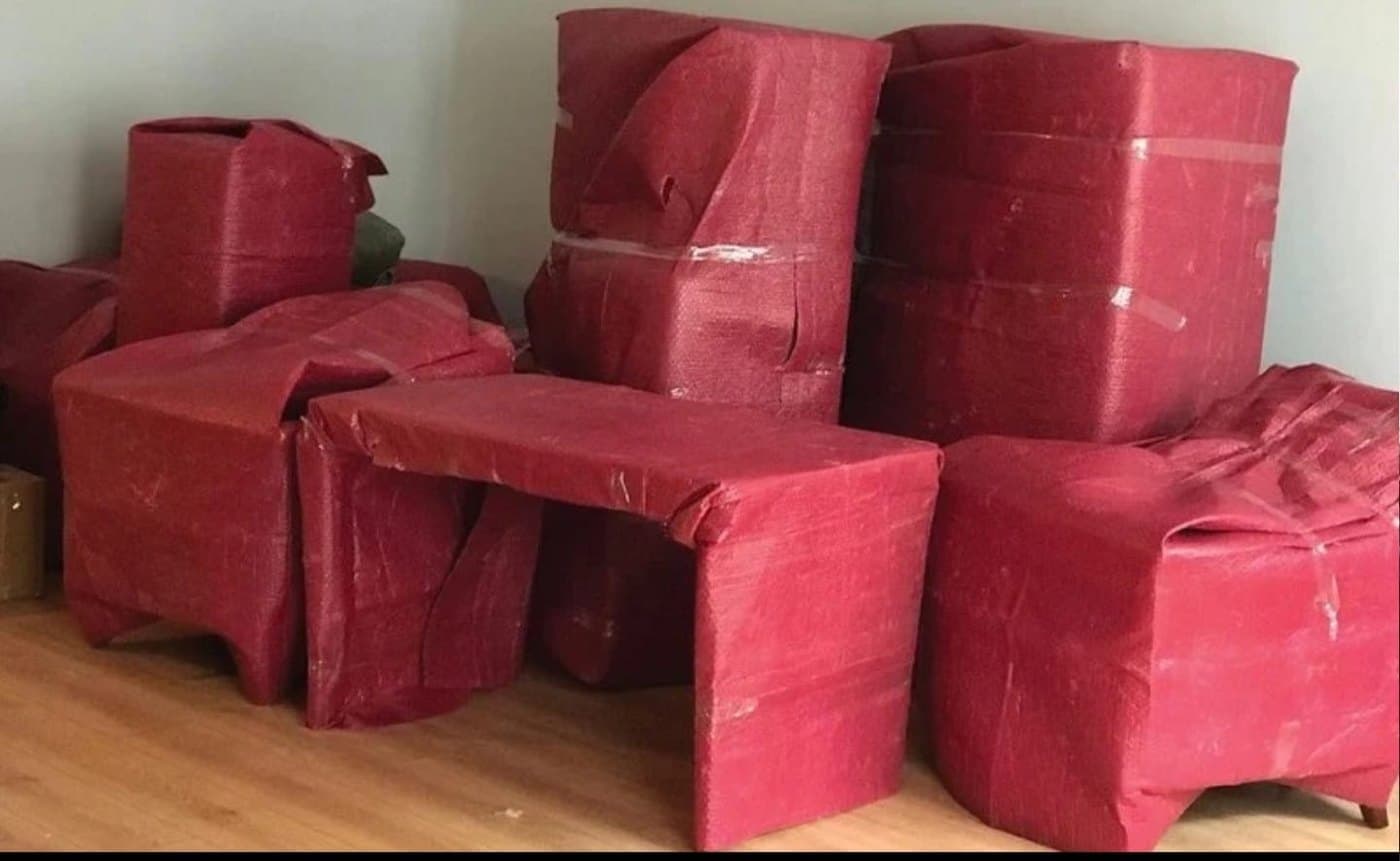 Ambalaj örtüsüyle sarılmış koltuk, sehpa ve komodinlerin bir odada toplanması